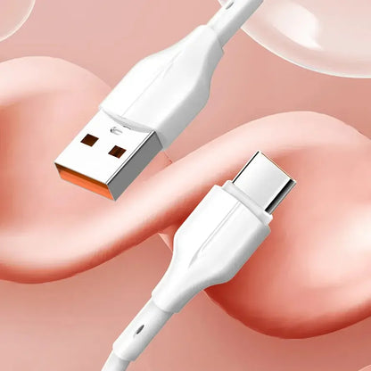 White USB to USB-C charging cable close-up on soft peach background
